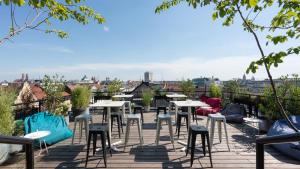 una fila di tavoli e sedie sul tetto di un edificio di Ruby Lilly Hotel Munich by IHG a Monaco