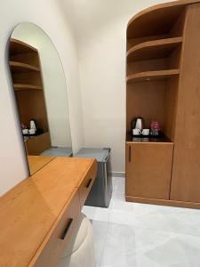 a room with a kitchen with a counter and shelves at Al Reef Garden in Sohar