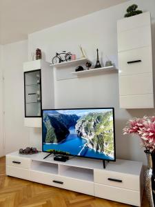 a tv sitting on a white stand in a living room at Lux Apartman Casablanca in Plužine