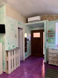 a kitchen with a purple tile floor and a door at Il tuo rifugio all' Argentario in Porto Santo Stefano