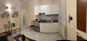 a kitchen with white cabinets and a table in a room at Guest House Michele in Orvieto Scalo