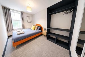 a bedroom with a bed and a large screen at Amazing City Centre Apartment in Derby