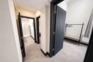 a bathroom with two mirrors and a walk in shower at Amazing City Centre Apartment in Derby