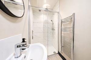 a white bathroom with a sink and a shower at Amazing City Centre Apartment in Derby +4 photos