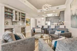 a living room with two couches and a table at Luxury GulfFront Penthouse with Resort Amenities in Dauphin Island