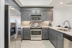 a kitchen with gray cabinets and stainless steel appliances at Luxury GulfFront Penthouse with Resort Amenities in Dauphin Island