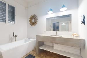 a bathroom with a large sink and a large mirror at White Sands Beach House in Maya Beach +25 photos