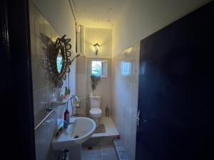 a bathroom with a sink and a toilet at Farissi's Zawya Surf House in Aourir +39 photos