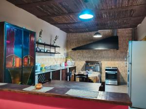 a large kitchen with a counter and a refrigerator at Hostel El Alamo in Maimará +18 photos