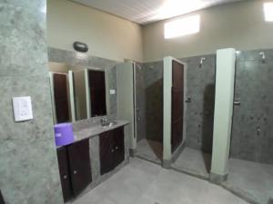 a bathroom with a shower and a sink and mirrors at Hostel El Alamo in Maimará