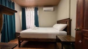 a bedroom with a bed and a window at Casa Pentagonia in Puerto Jiménez