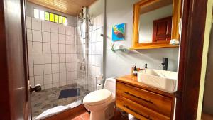 a bathroom with a toilet and a sink and a shower at Casa Pentagonia in Puerto Jiménez