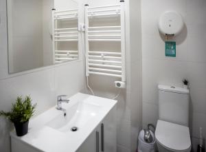 a white bathroom with a sink and a toilet at Metropolitano Guesthouse in Madrid +60 photos