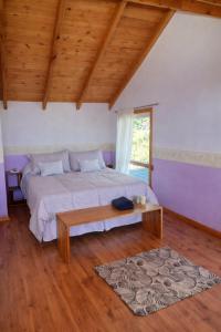 a bedroom with a large bed and a wooden ceiling at An Dina House in Dina Huapi