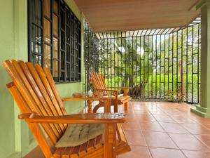 two chairs and a table on a porch with a window at Casa Pentagonia in Puerto Jiménez