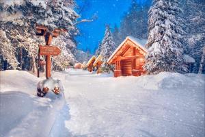 a snow covered path in front of a log cabin at Hotel Yastrebets Wellness & Spa in Borovets