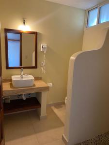a bathroom with a sink and a mirror at Hotel Villas Ema in Zihuatanejo