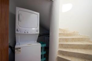 a television sitting on top of a refrigerator in a room at Shark Studio Retreat at Swan Villas - Gold Standard Certified in Maya Beach