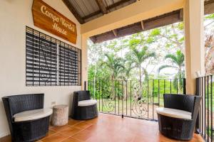 a room with two chairs and a balcony with a gate at Campo Verde House in San Ignacio