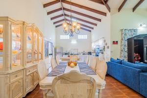 a dining room with a long table and a blue couch at Campo Verde House in San Ignacio