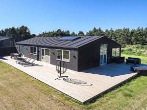 a small cabin with a deck with a house at Saltum Beach Luxury & Wellness in Saltum