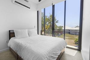 a bedroom with a bed and a large window at Beyond the Blue Casita in Placencia +8 photos