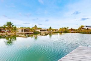 a large pool of water with a wooden dock at Seabird - Villa 17 in Placencia