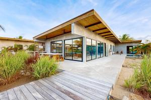 a modern house with a wooden deck and glass doors at Seabird - Villa 17 in Placencia