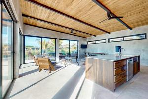 a kitchen with wooden ceilings and a dining room at Seabird - Villa 17 in Placencia
