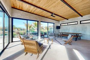 a living room with a ping pong table and windows at Seabird - Villa 17 in Placencia +41 photos
