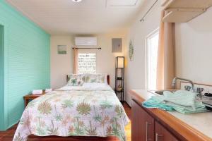 a bedroom with a bed and a sink in it at DV #2 at DV Cabanas -Gold Standard Certified in Caye Caulker