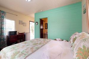 a bedroom with a green wall and a bed at DV #2 at DV Cabanas -Gold Standard Certified in Caye Caulker