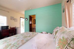 a bed in a room with a green wall at DV #2 at DV Cabanas -Gold Standard Certified in Caye Caulker