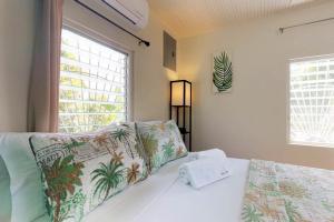 a bedroom with a bed with a pillow and a window at DV #2 at DV Cabanas -Gold Standard Certified in Caye Caulker +18 photos