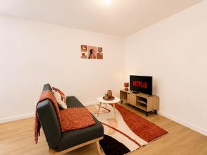 a living room with a chair and a tv at 8B - Le Cosy in Saint-Rambert-dʼAlbon