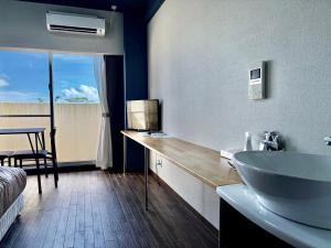 a bathroom with a sink and a bed and a tub at HOTEL Progress inn 名護 MATABee in Nago +33 photos