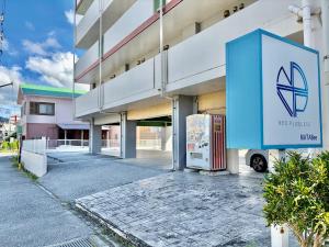 a building with a sign in front of it at HOTEL Progress inn 名護 MATABee in Nago