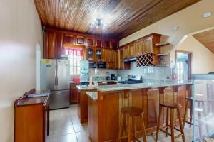 a kitchen with wooden cabinets and a stainless steel refrigerator at Spartan Unit 11 in Caye Caulker