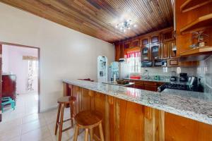 a kitchen with wooden cabinets and a counter with stools at Spartan Unit 11 in Caye Caulker +18 photos