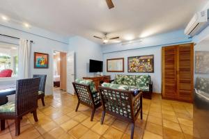 a living room with a couch and a table and chairs at Condo #24 @ Beachside Villas in Placencia