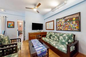 a living room with a couch and a flat screen tv at Condo #24 @ Beachside Villas in Placencia