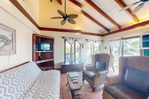 a living room with a couch and chairs and a ceiling fan at Condo #23 @ Beachside Villas in Placencia