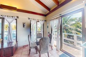 a dining room with a table and chairs and sliding glass doors at Condo #23 @ Beachside Villas in Placencia