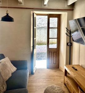 a living room with a blue couch and an open door at Casa Giù Là in Quarna Sopra