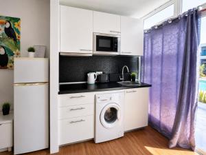 a kitchen with a washing machine and a microwave at Vanessa Puerto del Carmen in Tías