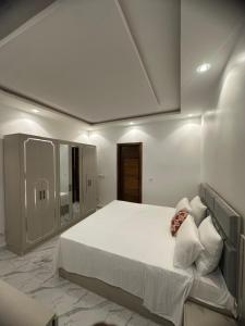 a bedroom with a large white bed in a room at Bayt Noor in Dakar