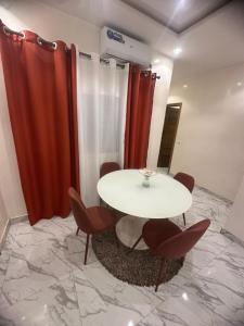 a table and chairs in a room with red curtains at Bayt Noor in Dakar