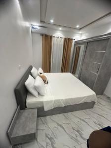 a bedroom with a large bed with white sheets and pillows at Bayt Noor in Dakar
