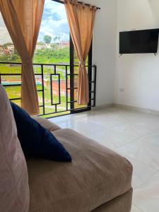 a living room with a couch and a large window at apartamento dúplex con balcón y central in Estación El Salto