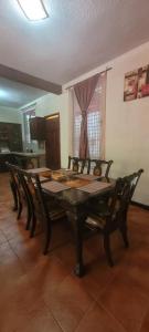 a dining room table and chairs with a table and a window at casa bugambilia in San Martín Zapotitlán